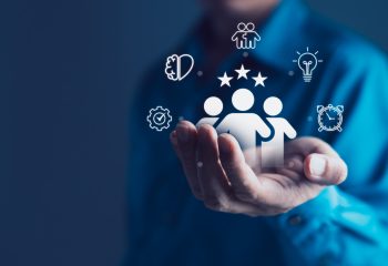 Businessman holding digital icons of a team with stars above, surrounded by productivity, innovation, collaboration symbols, human resource management, customer satisfaction, employee performance