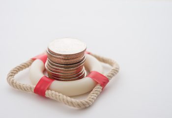 Stacked,Coins,In,Red,Lifebuoy,Or,Lifebelt,With,White,Background