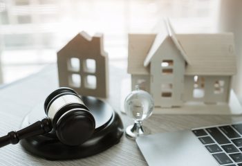 Judge gavel and house model on Notebook computer, Online Auction for Real Estate concept. Ideas for housing business judgment by E-commerce online goods services digital technology held over internet.