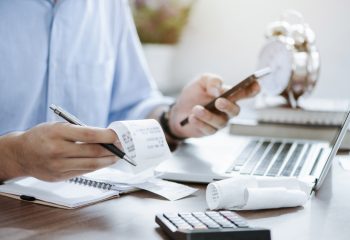 young man holding pen with bills working for calculate business data, taxes, bills payment, Start up counting finance. accounting, statistics, and analytic research concept