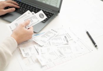 Hands of a man preparing tax return documents.The material in the image is Japanese tax format paper and there are no copyright issues.