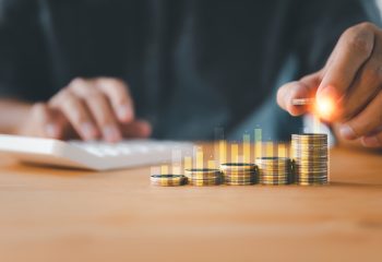 Increasing,Graph,Of,A,Businessman's,Hand,With,Money,Coins,Stacking,
