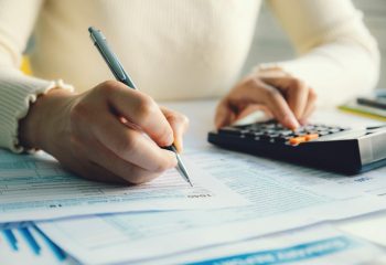 Closeup woman filling form of Individual Income Tax Return,