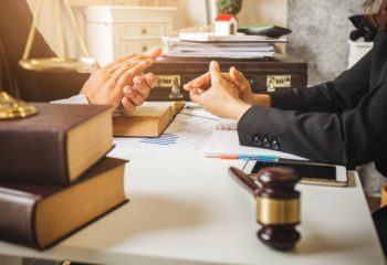 The hard work of an asian lawyer in a lawyer's office. Counseling and giving advice and prosecutions about the invasion of space between private and government officials to find a fair settlement.