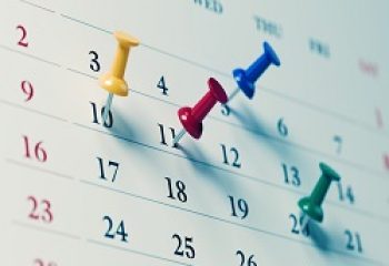 White calendar with colored push pins  reminding important dates. Calendar and reminder concept. Horizontal composition with copy space.