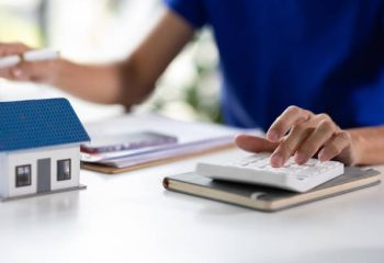 Man calculating income, expenses and appraising house value, Real estate financial planning.