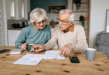 Mature couple going over financial bills in their domestic kitchen