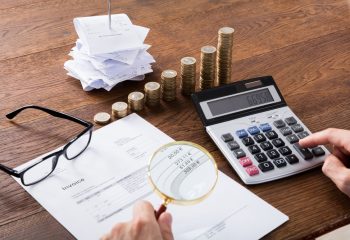 Auditor,Hand,Checking,Invoice,Using,Magnifying,Grass.,Tax,Fraud,Investigation