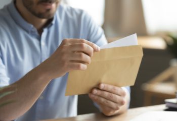 Close,Up,Young,Man,Opening,Envelope,With,Paper,Correspondence.,Curious